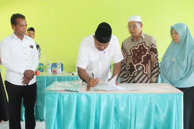 Penandatanganan berita acara serah terima oleh Ketua Komite, Drs. H. A. Rajak Lotar, M.Si